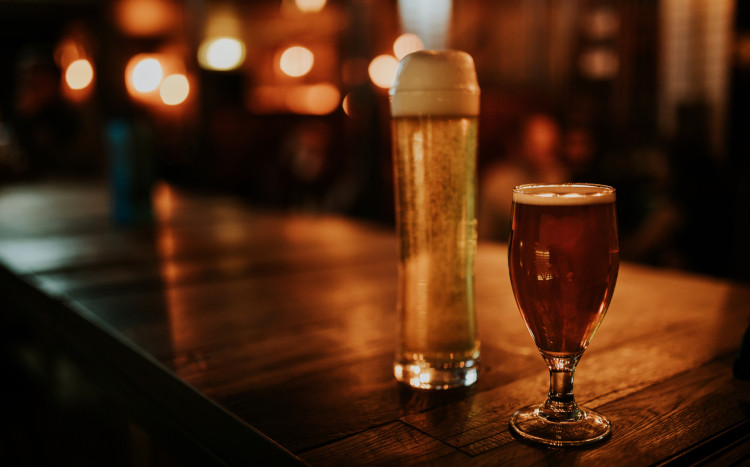 dwie szklanki piwa stojące na barze