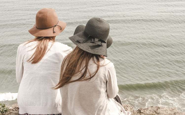 Przyjaciółki nad morzem w kapeluszach.