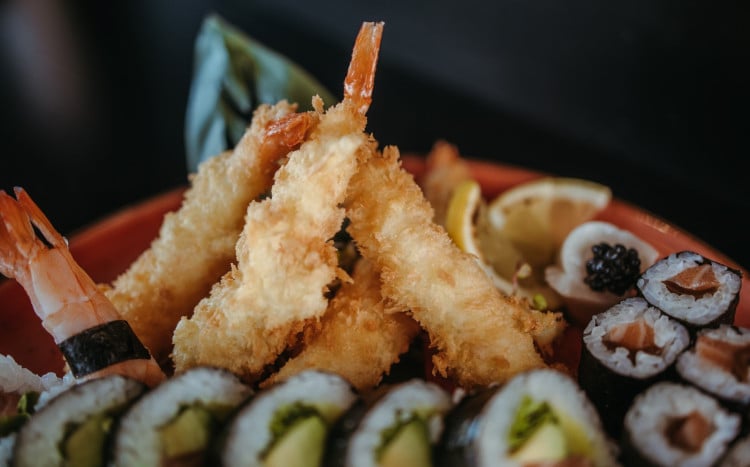 Krewetki w tempurze w otoczeniu rolek sushi