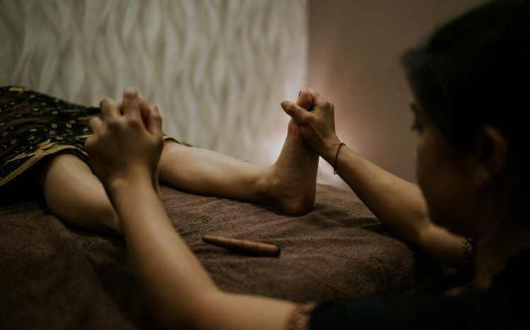 Kobieta wykonuje masaż stóp