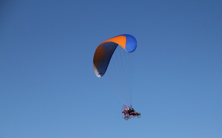 Motoparalotnia z pomarańczowo-niebieskim spadochronem