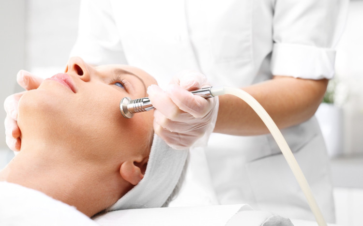 leżąca kobieta na zabiegu pielęgnacyjnym na twarz w salonie SPA