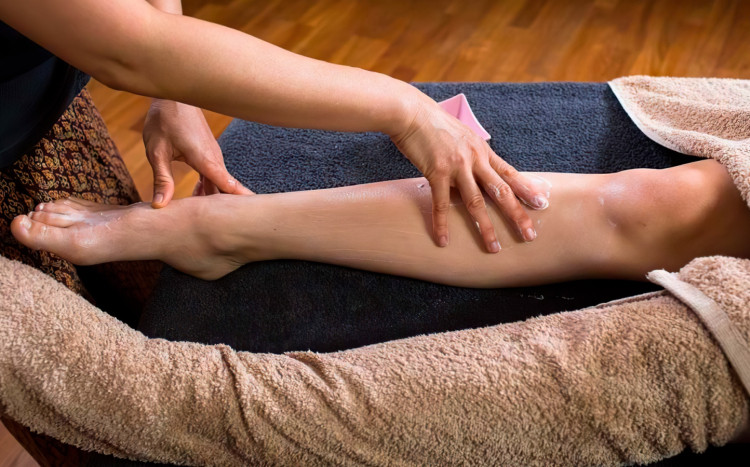 kobieta wykonuje masaż stóp