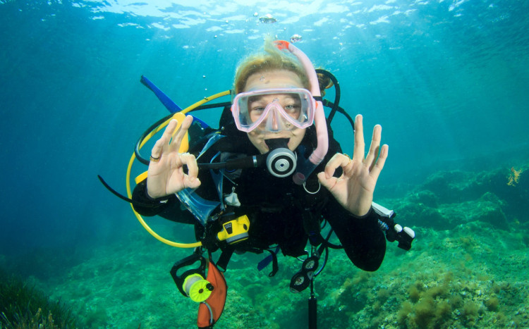 kobieta pokazuje znak ok pod wodą