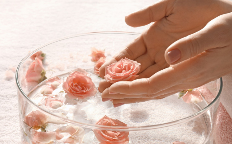 kąpiel dłoni w wodzie z płatkami róż