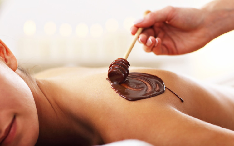 masażystka rozciera czekoladę na plecach