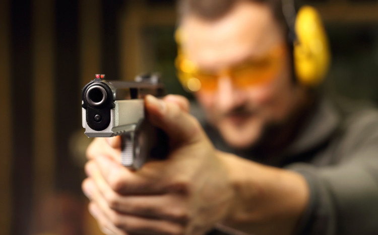 mężczyzna strzela z broni na strzelnicy