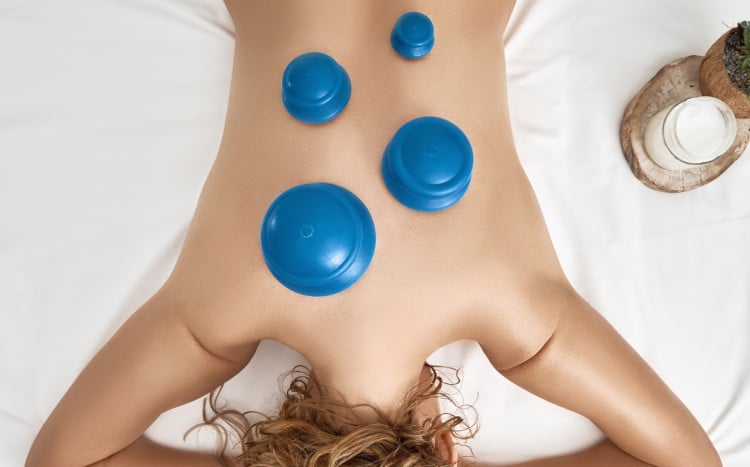 kobieta leży na brzuchu z 4 niebieskimi bańkami chińskimi o różnej wielkości