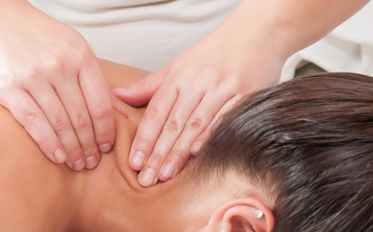 masowanie karku kobiety w gabinecie masażu