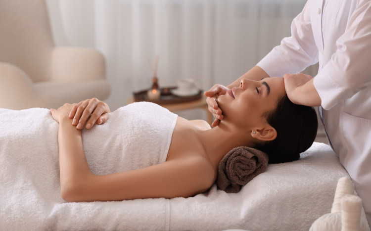 masażystka masuje twarz kobiety w spa
