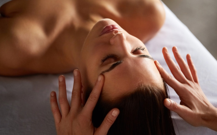 masażystka masuje skronie kobiety podczas masażu twarzy