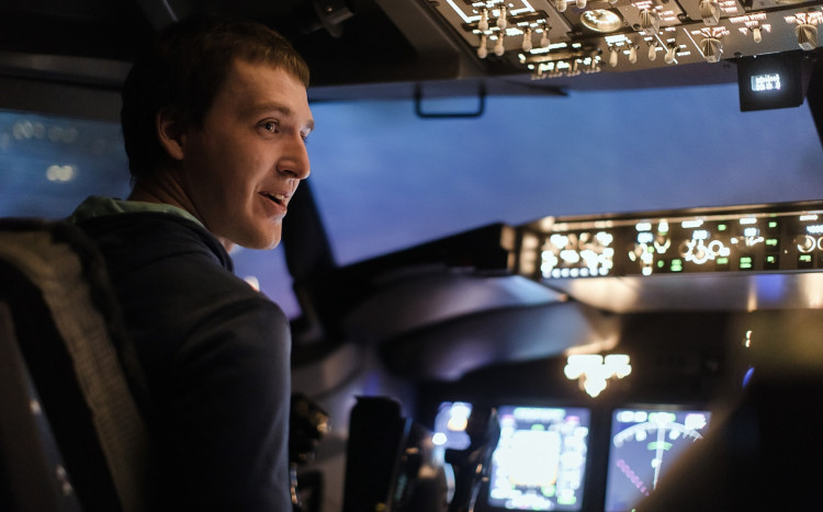młody mężczyzna uczy się latać samolotem w symulatorze