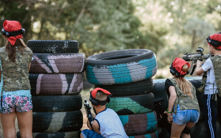 dzieci za oponami grają w paintball