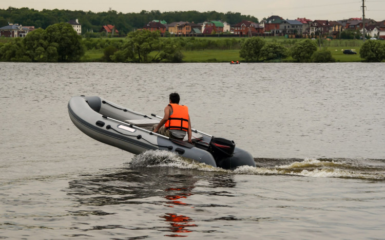 mężczyzna pływa pontonem motorowym