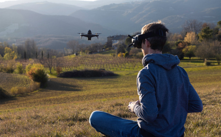 mężczyzna lata dronem w górach