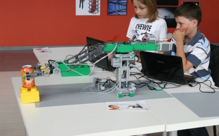 dzieci programują robota do podnoszenia puszki z napojem