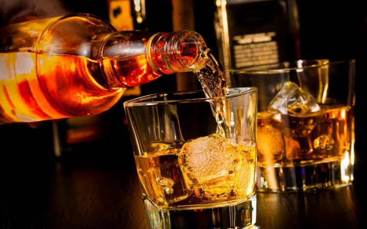 nalewanie whisky do szklanki z lodem